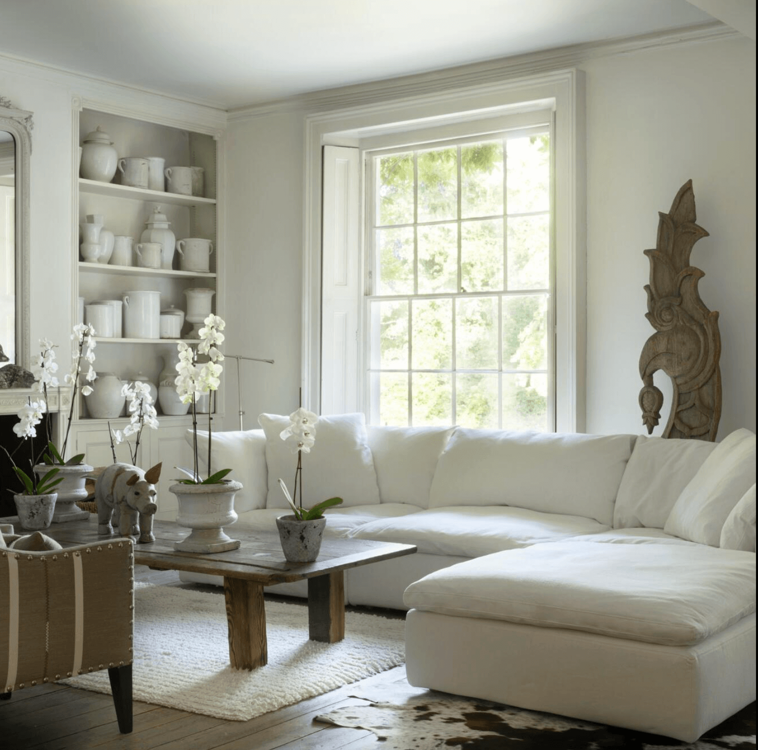 The Truman sofa by Andrew Martin is enhanced by plants, vintage jars and reclaimed wood